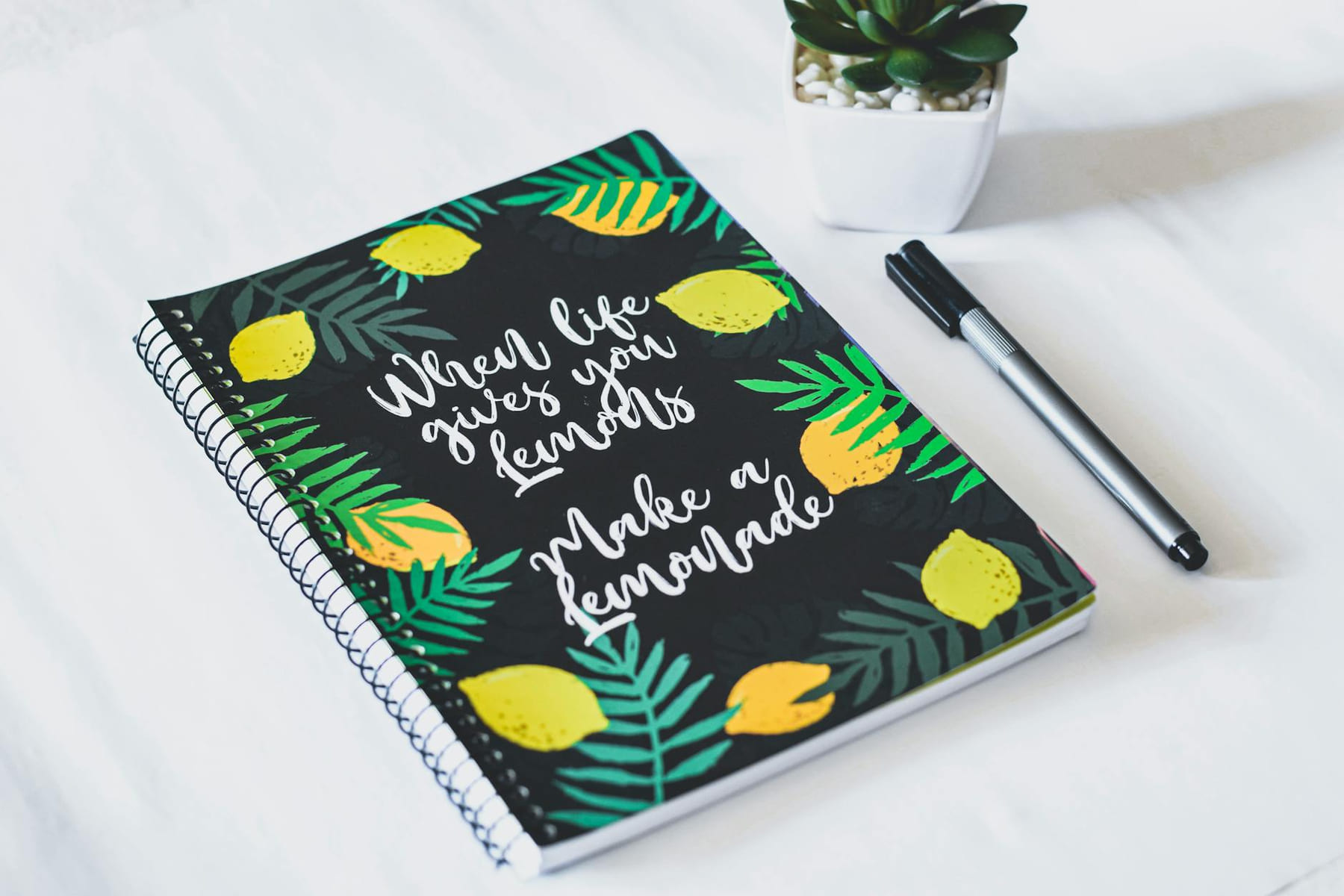 Spiral notebook with a motivational lemon-themed cover and a pen, perfect for journaling or note-taking. on Inner Progress Project
