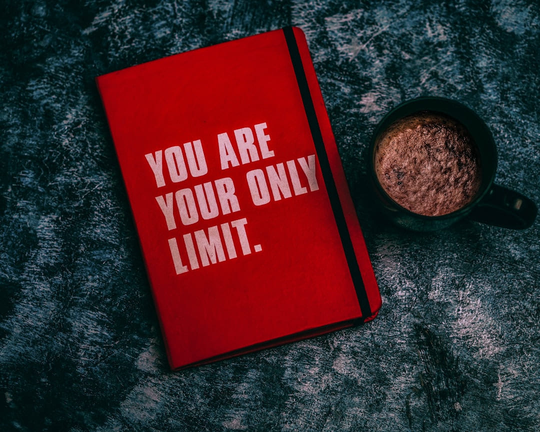 a red book with the words you are your only limit next to a cup of on Inner Progress Project