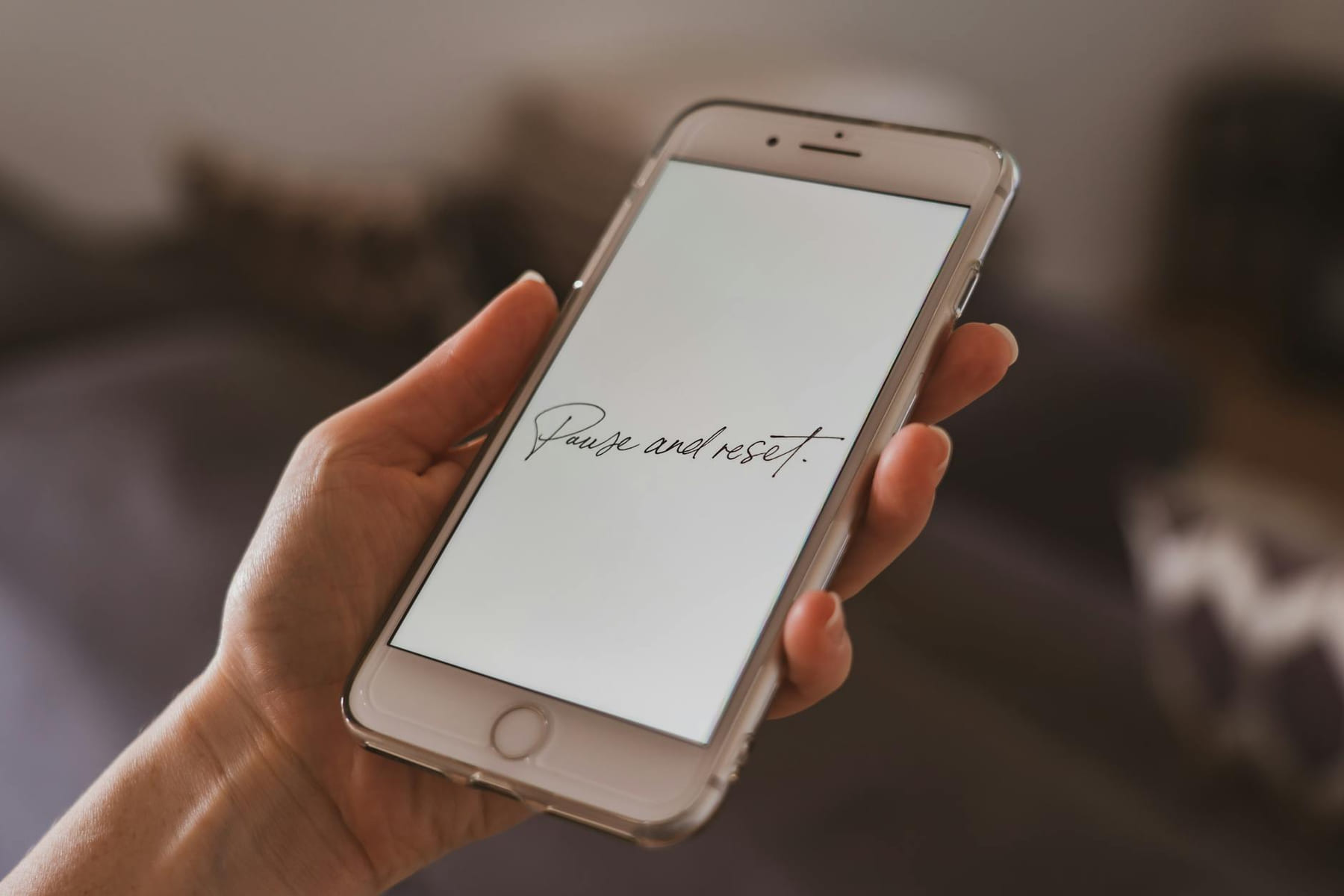A hand holding a smartphone with a motivational quote on the screen, suggesting reflection. on Inner Progress Project