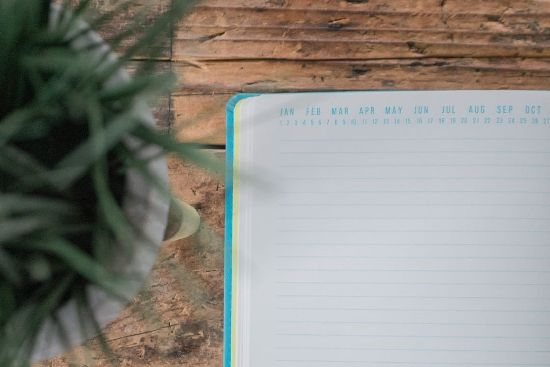 white notebook on wooden surface on Inner Progress Project